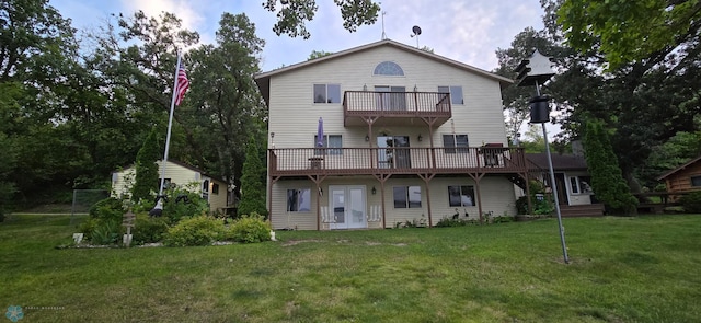 back of house with a lawn and a balcony