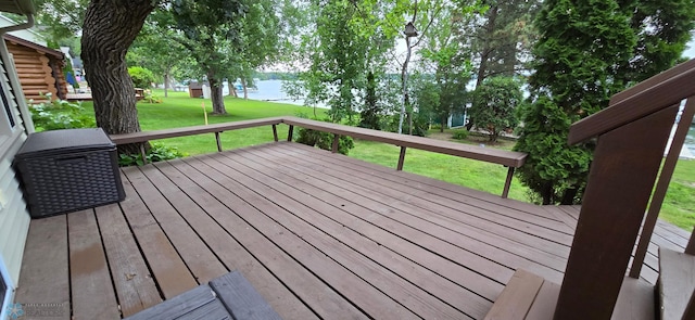 wooden deck with a water view and a lawn