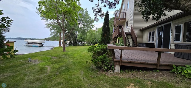 view of yard with a deck with water view and stairs