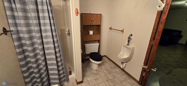 bathroom featuring toilet, a shower with curtain, and baseboards