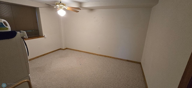 unfurnished room with baseboards, washer / clothes dryer, a ceiling fan, and light colored carpet