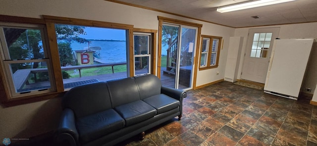 interior space featuring ornamental molding, stone finish flooring, and baseboards