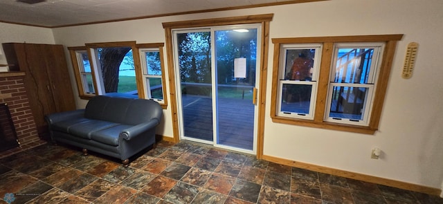 unfurnished room featuring stone finish flooring, baseboards, and crown molding