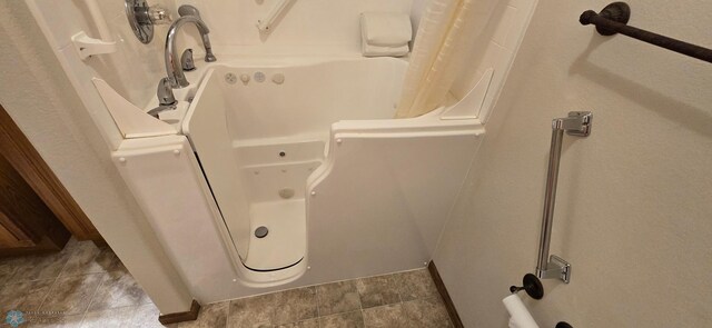 bathroom with a shower with curtain and tile patterned floors