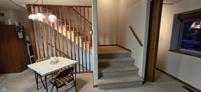 staircase with baseboards, carpet floors, visible vents, and a notable chandelier