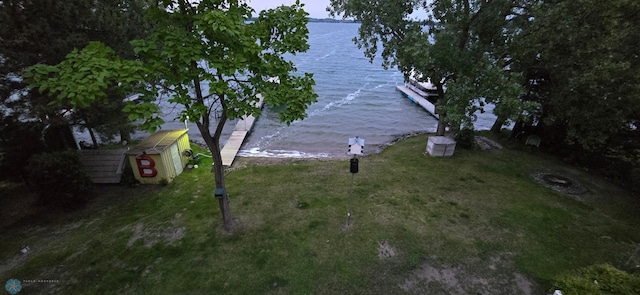 exterior space featuring a water view, a storage shed, and an outbuilding