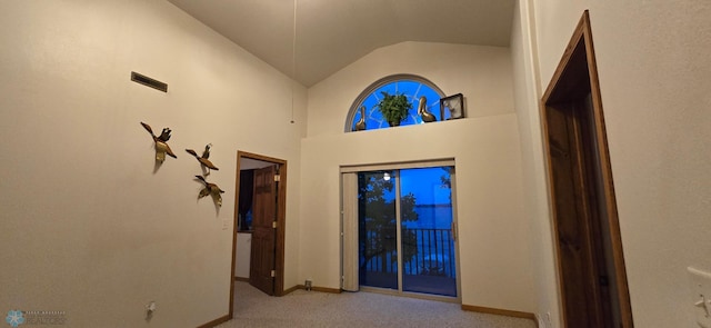 entrance foyer with lofted ceiling, light carpet, and baseboards