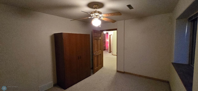 hallway featuring light carpet and baseboards