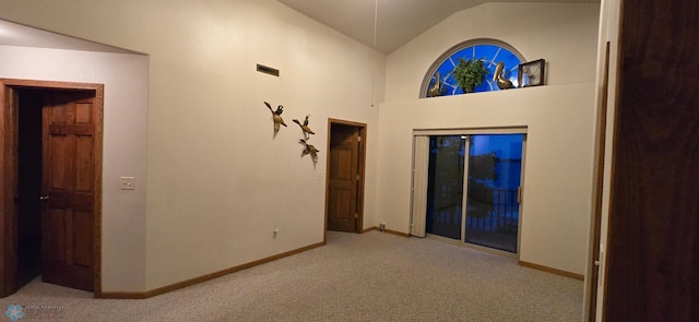 spare room with light carpet, visible vents, baseboards, and vaulted ceiling