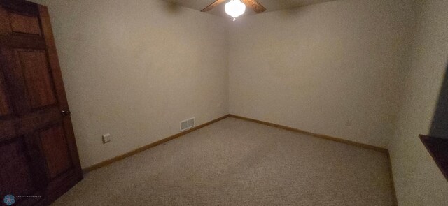 spare room with carpet floors, a ceiling fan, visible vents, and baseboards