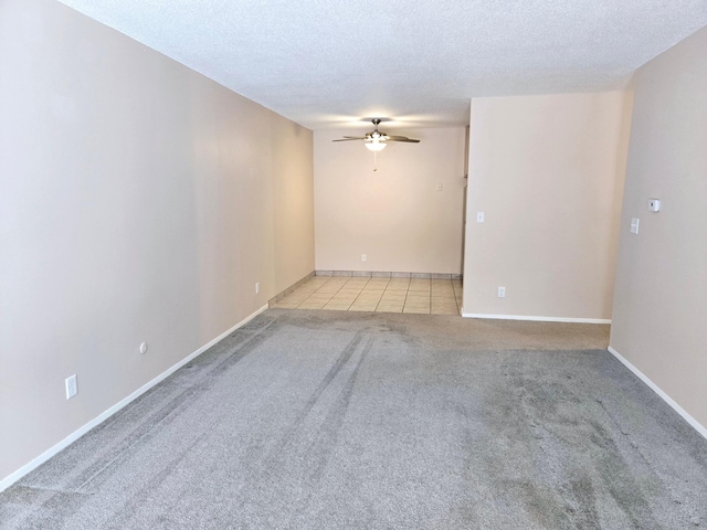 tiled empty room featuring ceiling fan and a textured ceiling