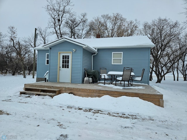 snow covered house featuring a deck