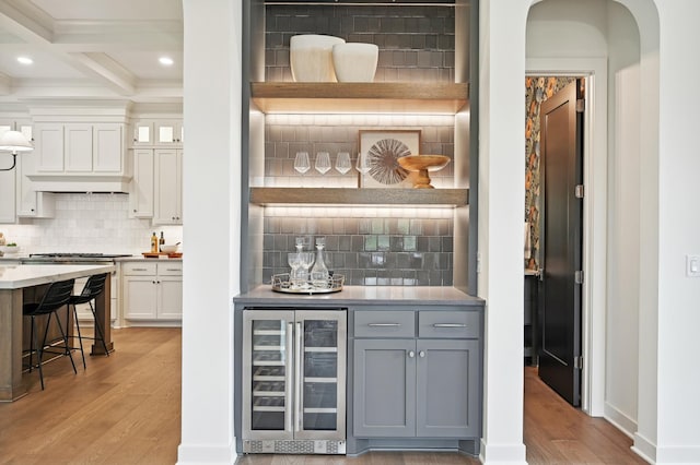 bar with wine cooler, white cabinetry, light hardwood / wood-style flooring, and gray cabinets