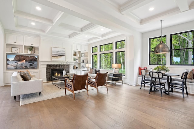 living room featuring a brick fireplace, a healthy amount of sunlight, and light hardwood / wood-style floors