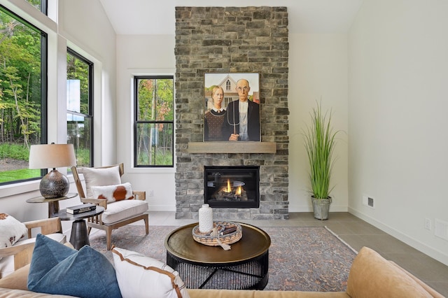 tiled living room featuring lofted ceiling and a fireplace