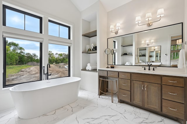 bathroom featuring vanity, built in shelves, vaulted ceiling, and a bathing tub