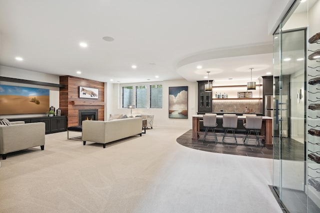 living room featuring a large fireplace, wood walls, and carpet flooring