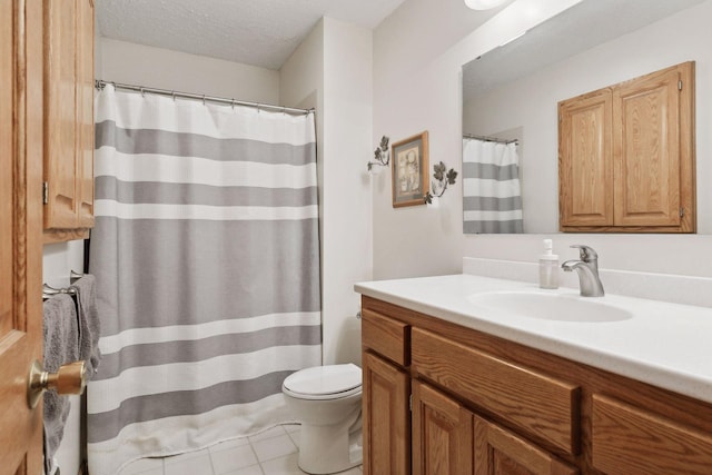 bathroom with a textured ceiling, toilet, vanity, and tile patterned floors