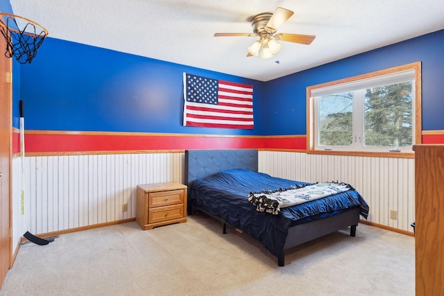 carpeted bedroom featuring ceiling fan and a textured ceiling