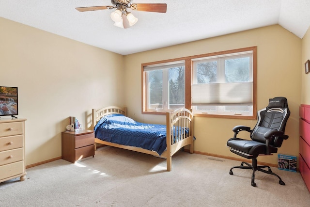 bedroom featuring ceiling fan, vaulted ceiling, a textured ceiling, and light colored carpet