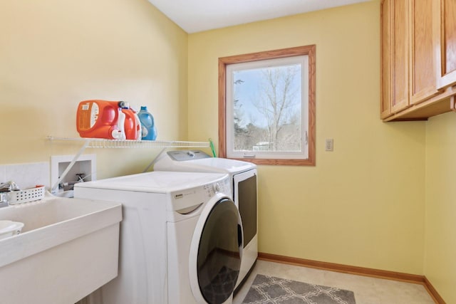 laundry area featuring sink, washer and clothes dryer, and cabinets