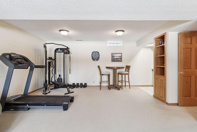 workout room with light carpet and a textured ceiling