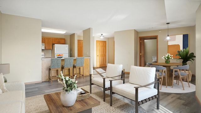 living area featuring light wood-type flooring and baseboards