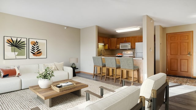 living room featuring dark wood-type flooring and baseboards