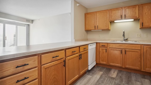 kitchen featuring wood finished floors, a sink, visible vents, light countertops, and dishwasher