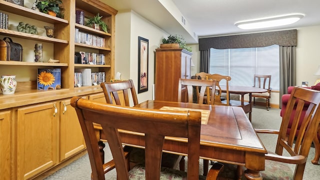 dining space with light colored carpet and visible vents