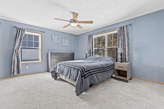 bedroom featuring light carpet, ceiling fan, and a textured ceiling