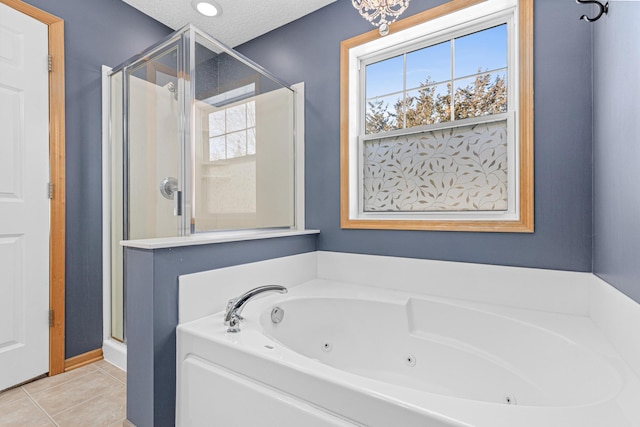 bathroom with tile patterned floors, plus walk in shower, and a textured ceiling