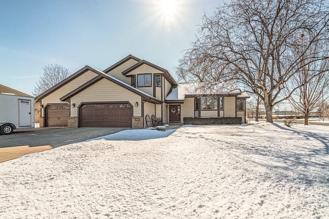 view of front facade featuring aphalt driveway, brick siding, and an attached garage