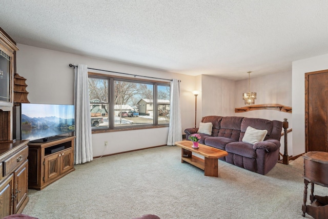 living room with an inviting chandelier, baseboards, a textured ceiling, and light colored carpet