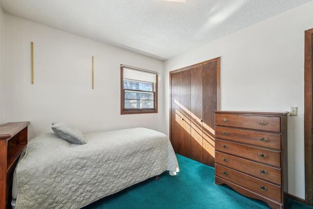 bedroom featuring a textured ceiling, carpet floors, and a closet