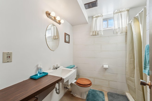 full bathroom with toilet, curtained shower, visible vents, and a sink