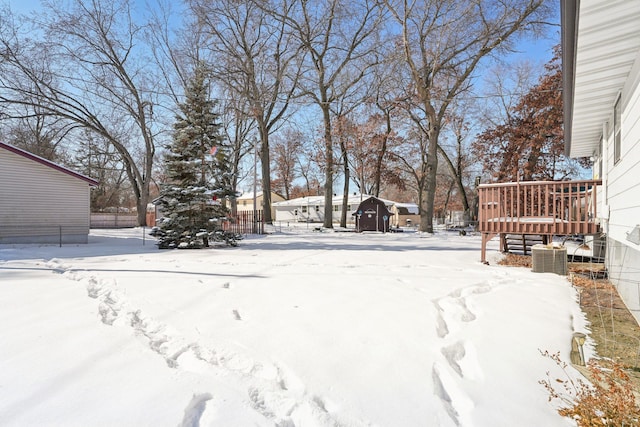 yard layered in snow featuring fence and a wooden deck