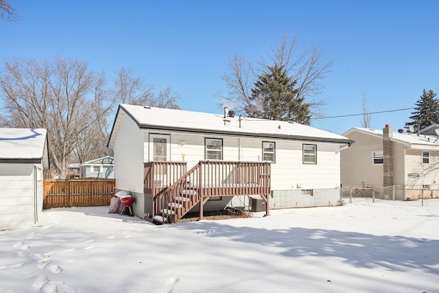 snow covered back of property featuring cooling unit, crawl space, fence, and a wooden deck