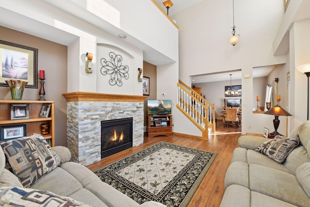 living room with a fireplace, light hardwood / wood-style floors, and a high ceiling