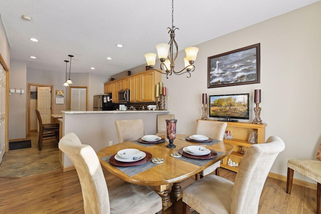 dining room featuring a notable chandelier and light hardwood / wood-style flooring