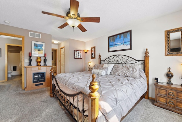 bedroom featuring ceiling fan, light colored carpet, a textured ceiling, and a closet