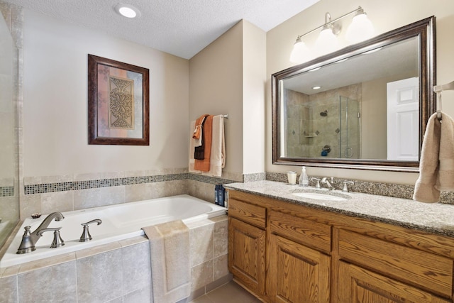 bathroom featuring tile patterned floors, vanity, separate shower and tub, and a textured ceiling