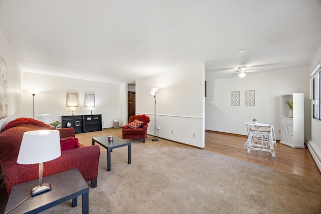 living area with a ceiling fan, carpet flooring, baseboards, and wood finished floors