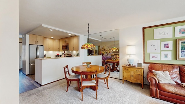 dining room with recessed lighting and light colored carpet