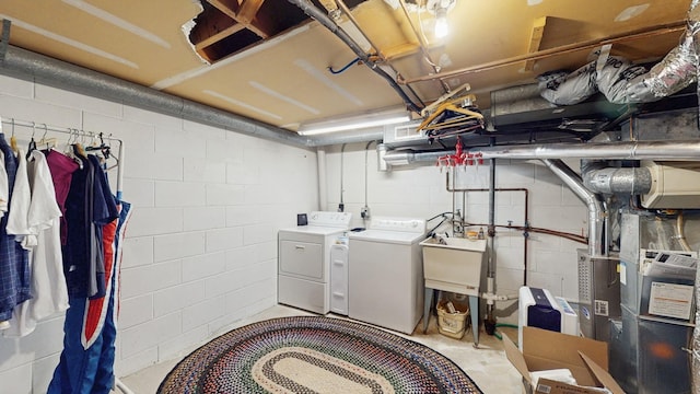 clothes washing area with laundry area, washer and dryer, and a sink