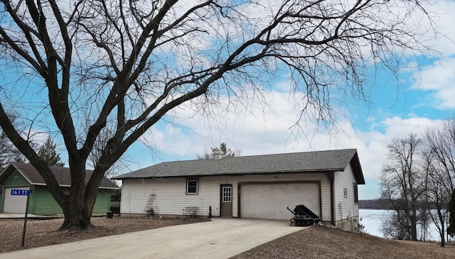 view of property exterior featuring a garage, concrete driveway, and roof with shingles