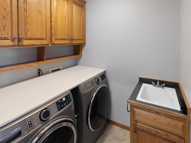 washroom with sink, cabinets, and washer and dryer