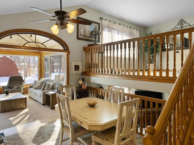 carpeted dining space featuring ceiling fan, vaulted ceiling, and a wealth of natural light