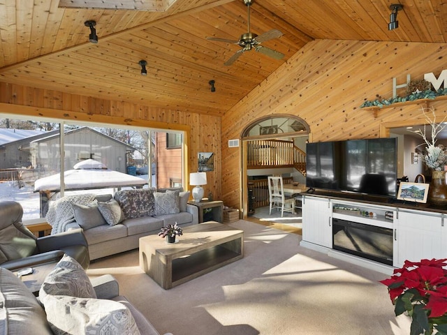 living room featuring ceiling fan, high vaulted ceiling, light carpet, wooden ceiling, and wood walls