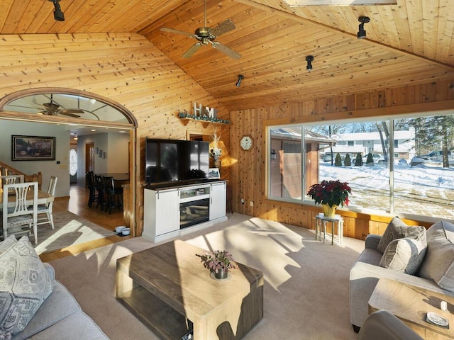 living room featuring ceiling fan, light carpet, wooden ceiling, and wooden walls